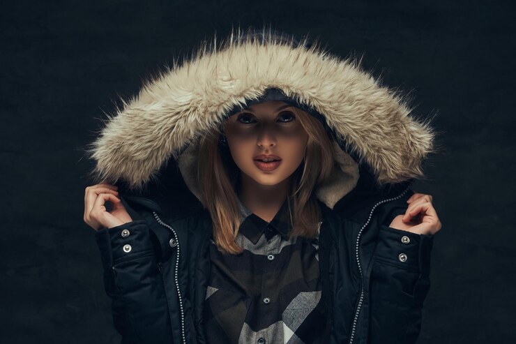 portrait-sensual-blonde-girl-winter-jacket-fur-hood-standing-studio-isolated-dark-background_613910-19411